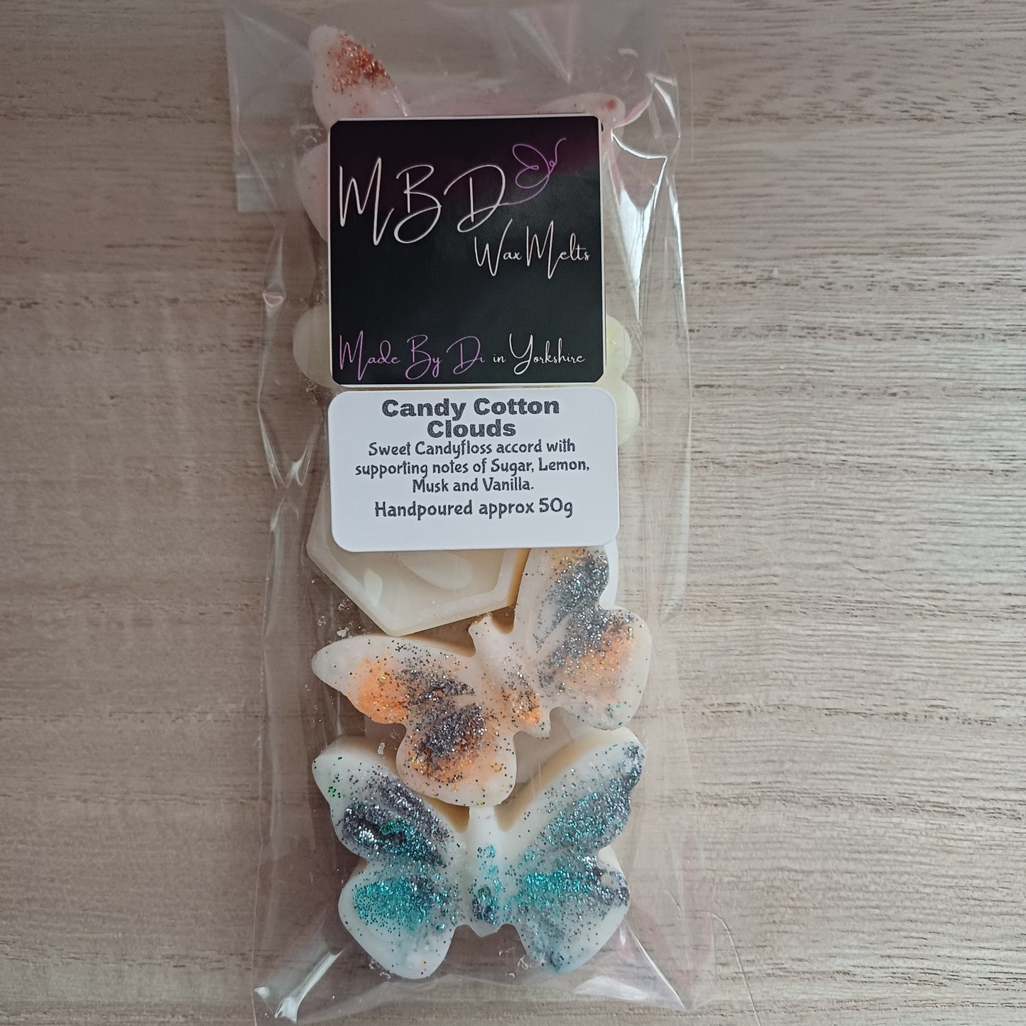Packaged Decorative Butterfly and Bee Wax Melts on wooden surface.