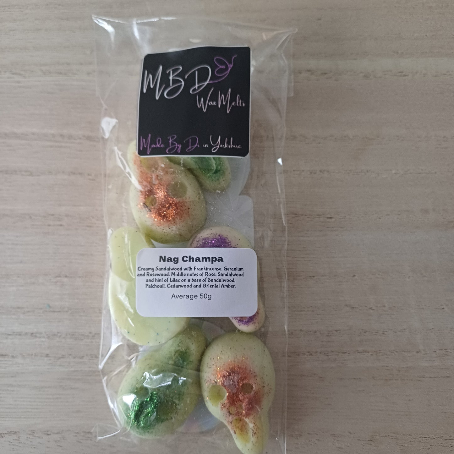 Packaged Nag Champa Wax Melts on a wooden surface