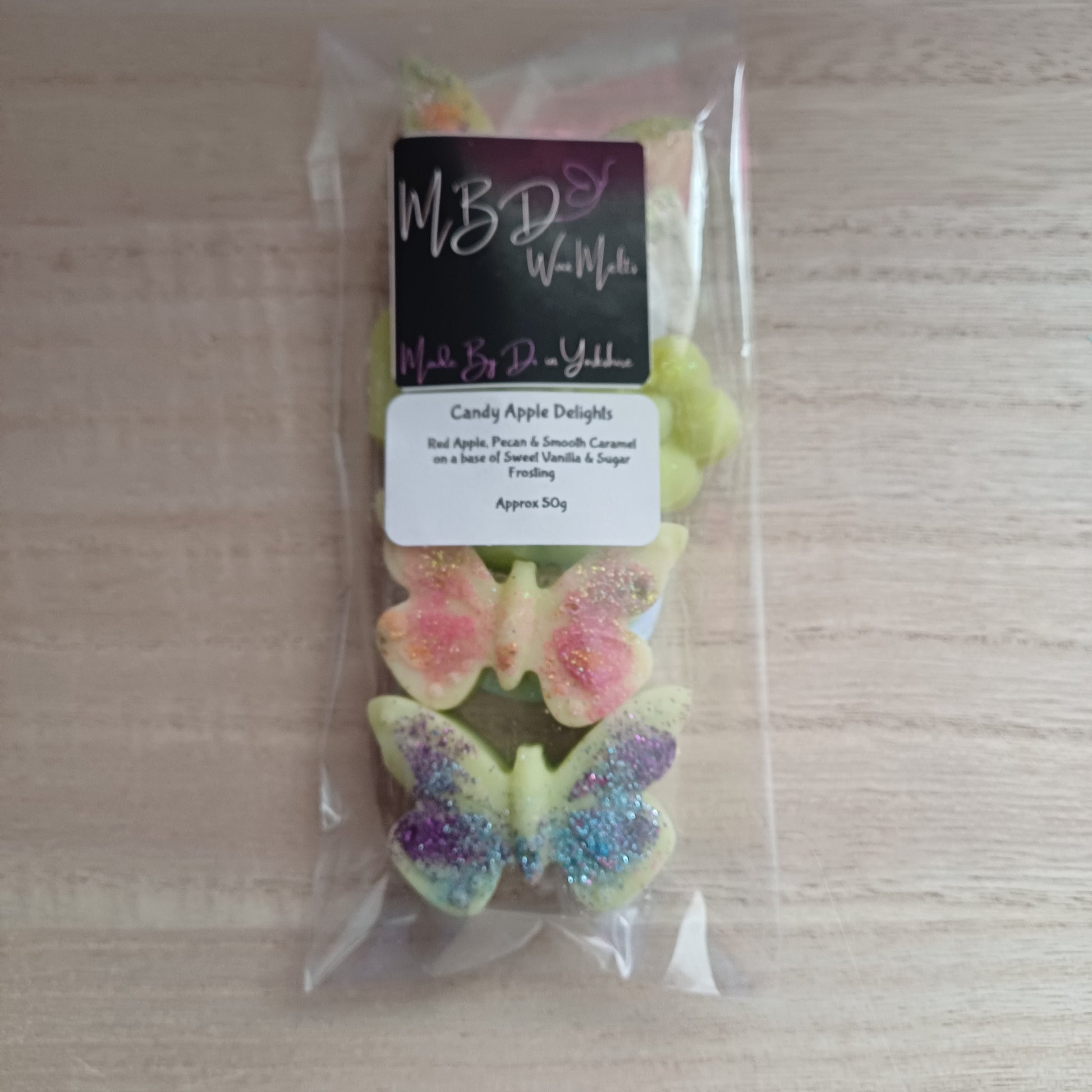 Packaged Butterfly and flower wax melts on a wooden surface