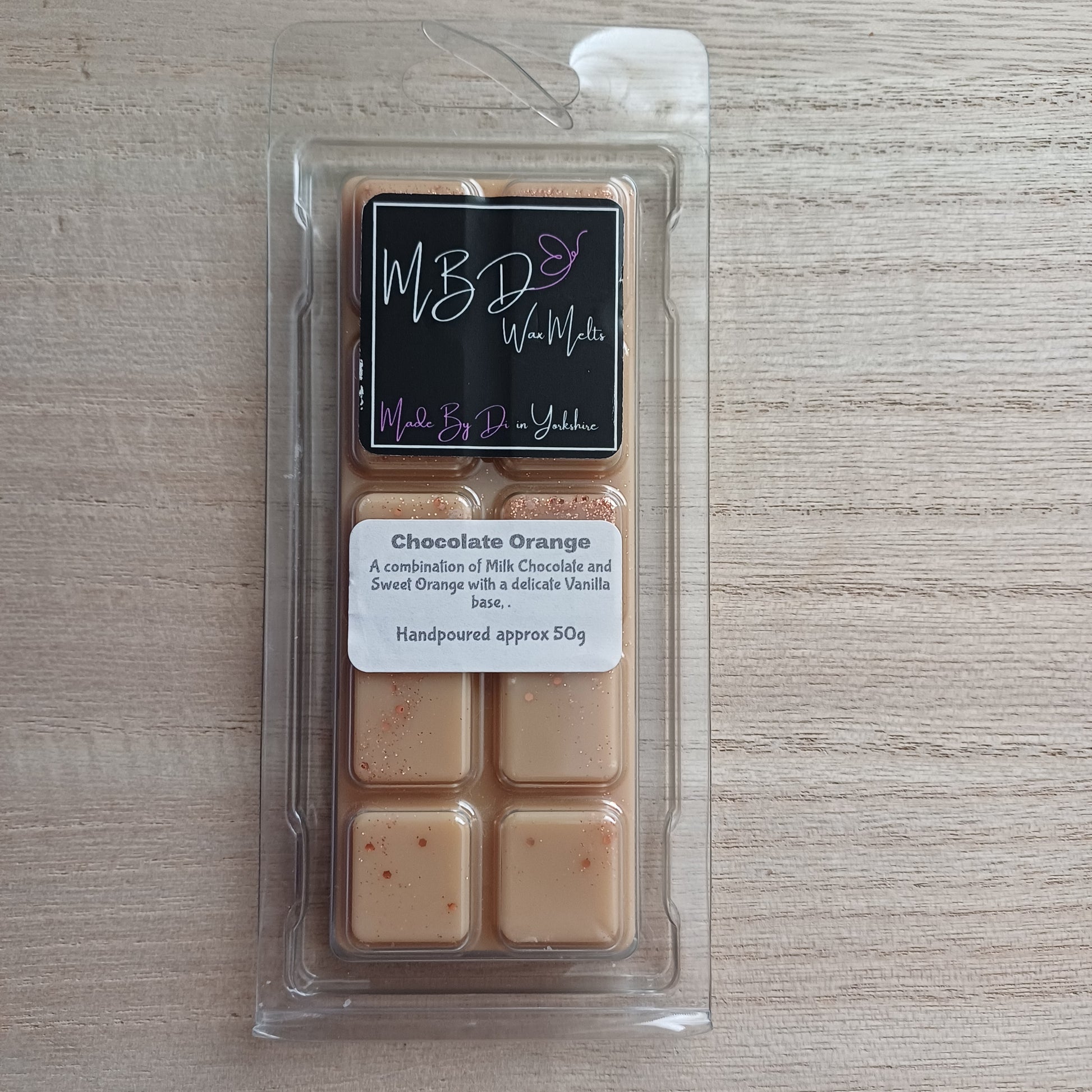 Packaged Chocolate Orange Wax melts on a wooden surface