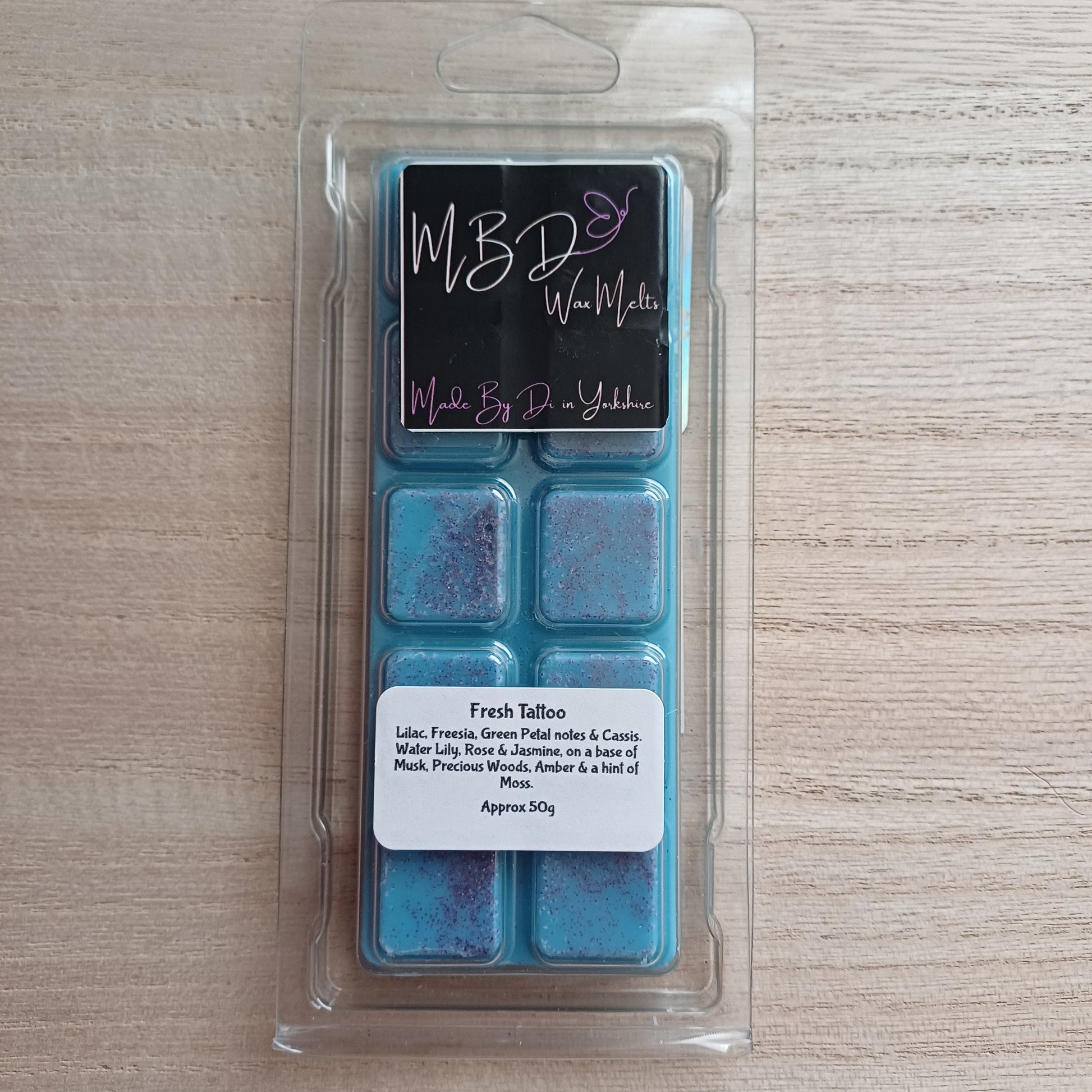 Packaged wax melts with MBD label on a wooden Surface