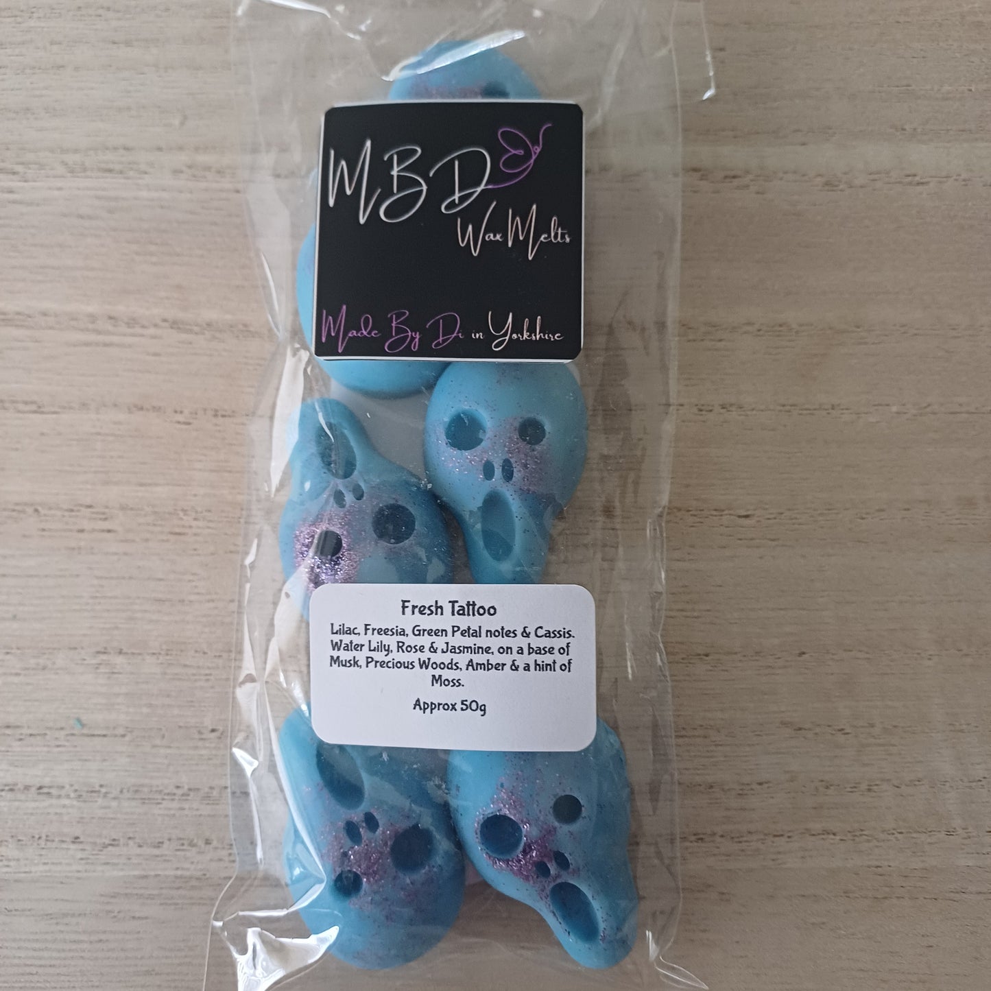 Packaged Blue Skull Shaped Wax Melts on a wooden Surface