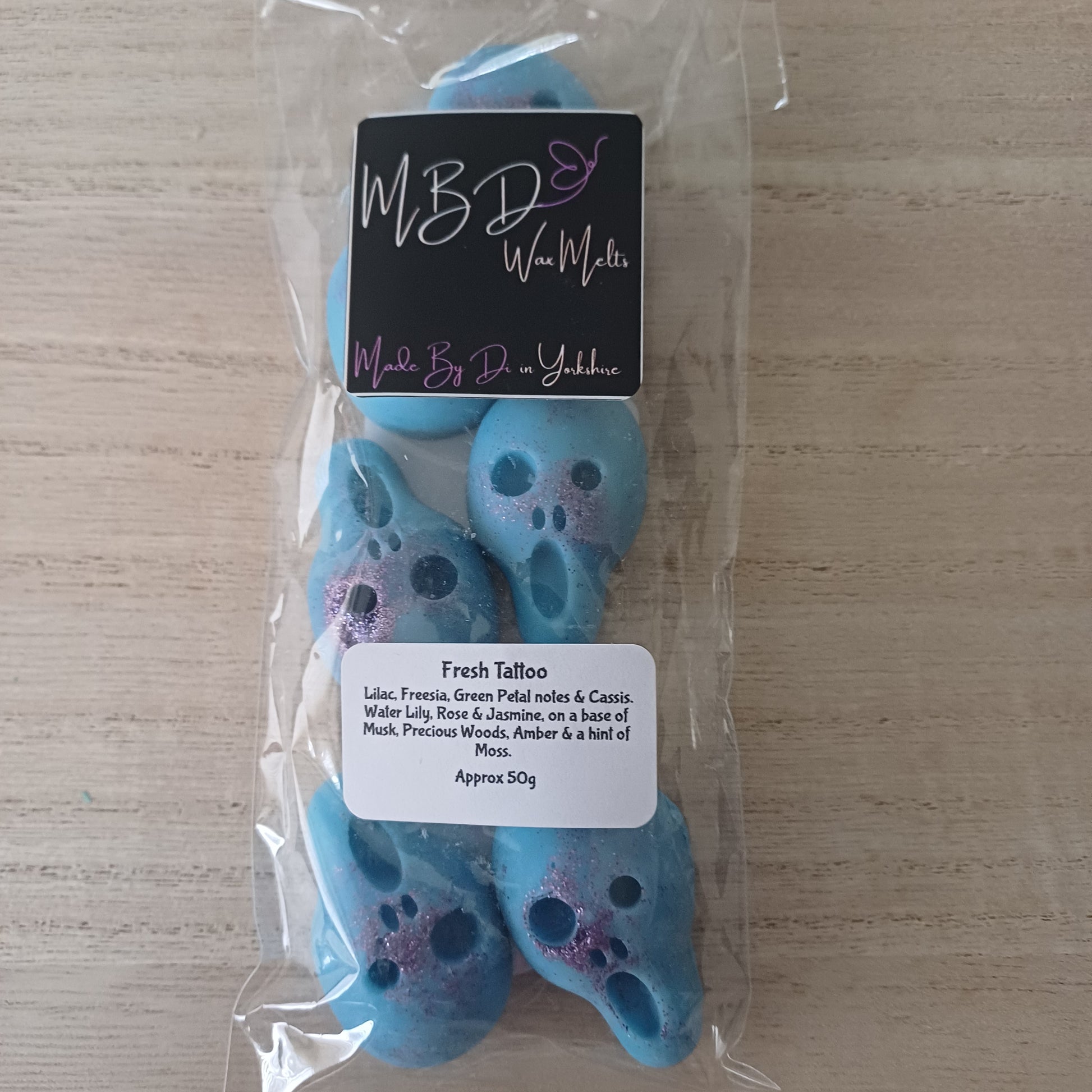 Packaged Blue Skull Shaped Wax Melts on a wooden Surface