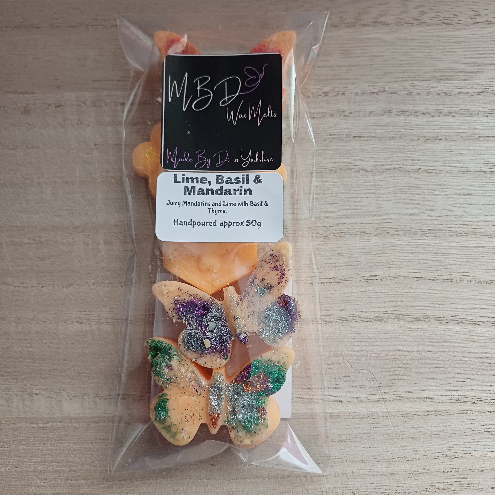 Packaged Butterfly, Bee and Flower wax melts on a wooden surface.