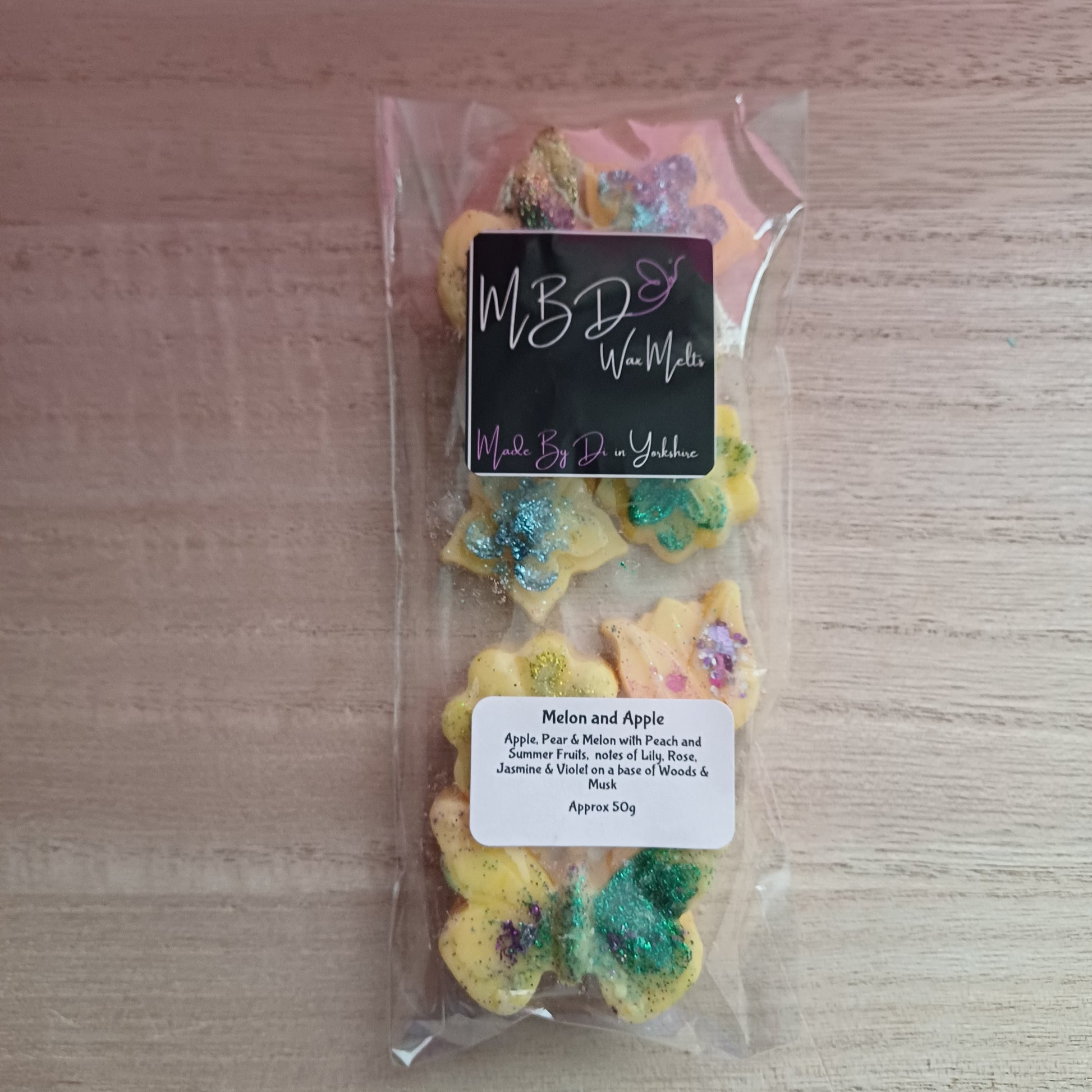 Packaged shaped wax melts on a wooden background.
