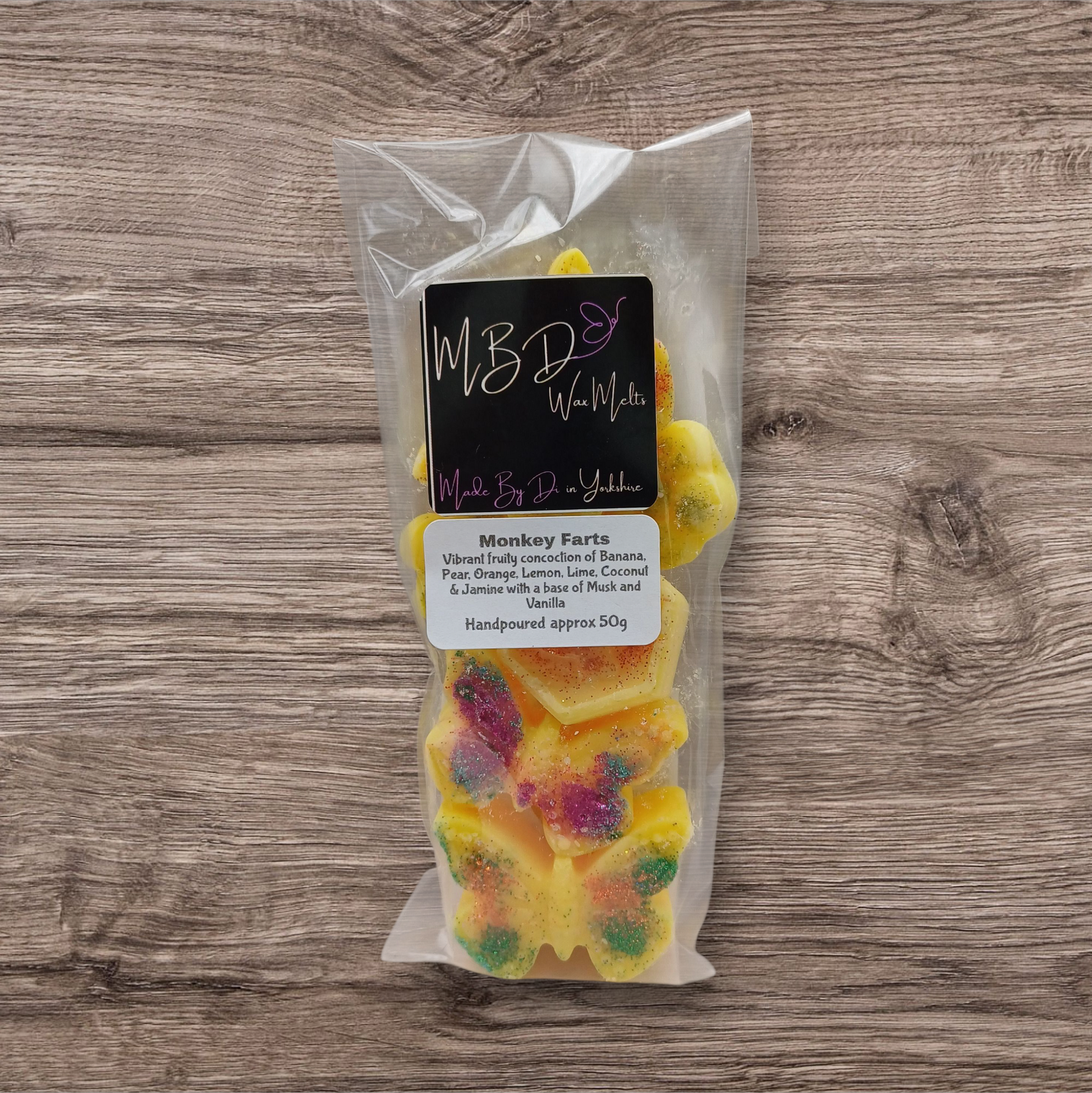 Packaged Wax Melts with a brand label on a wooden surface