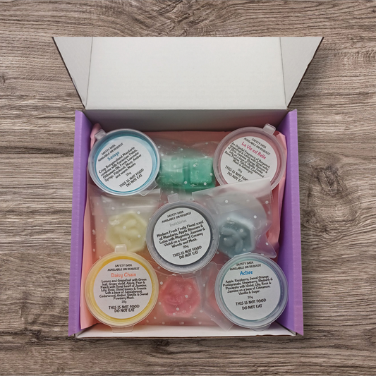 Set of delipots with lids in a box on a wooden surface