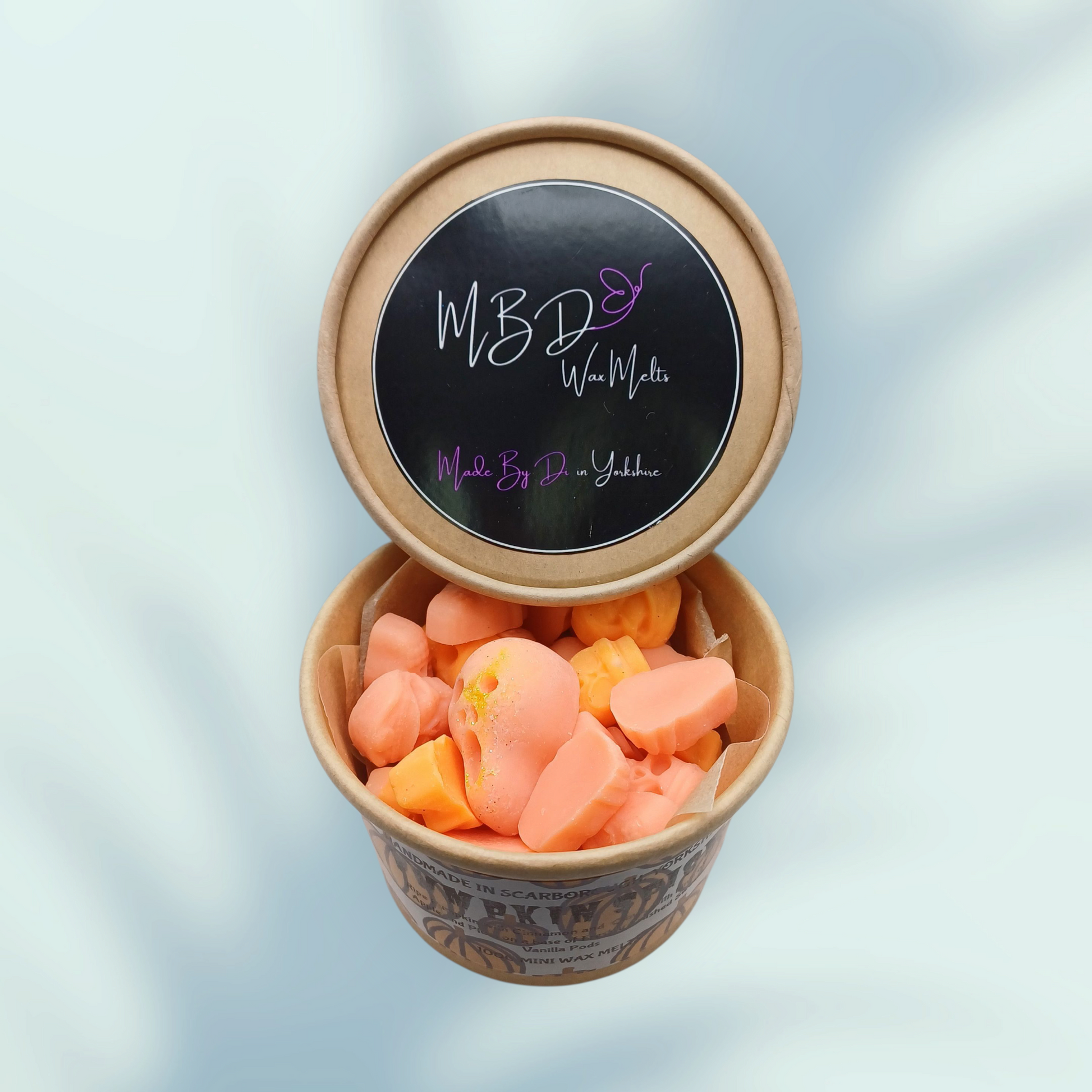 Open Container of orange mini wax melts