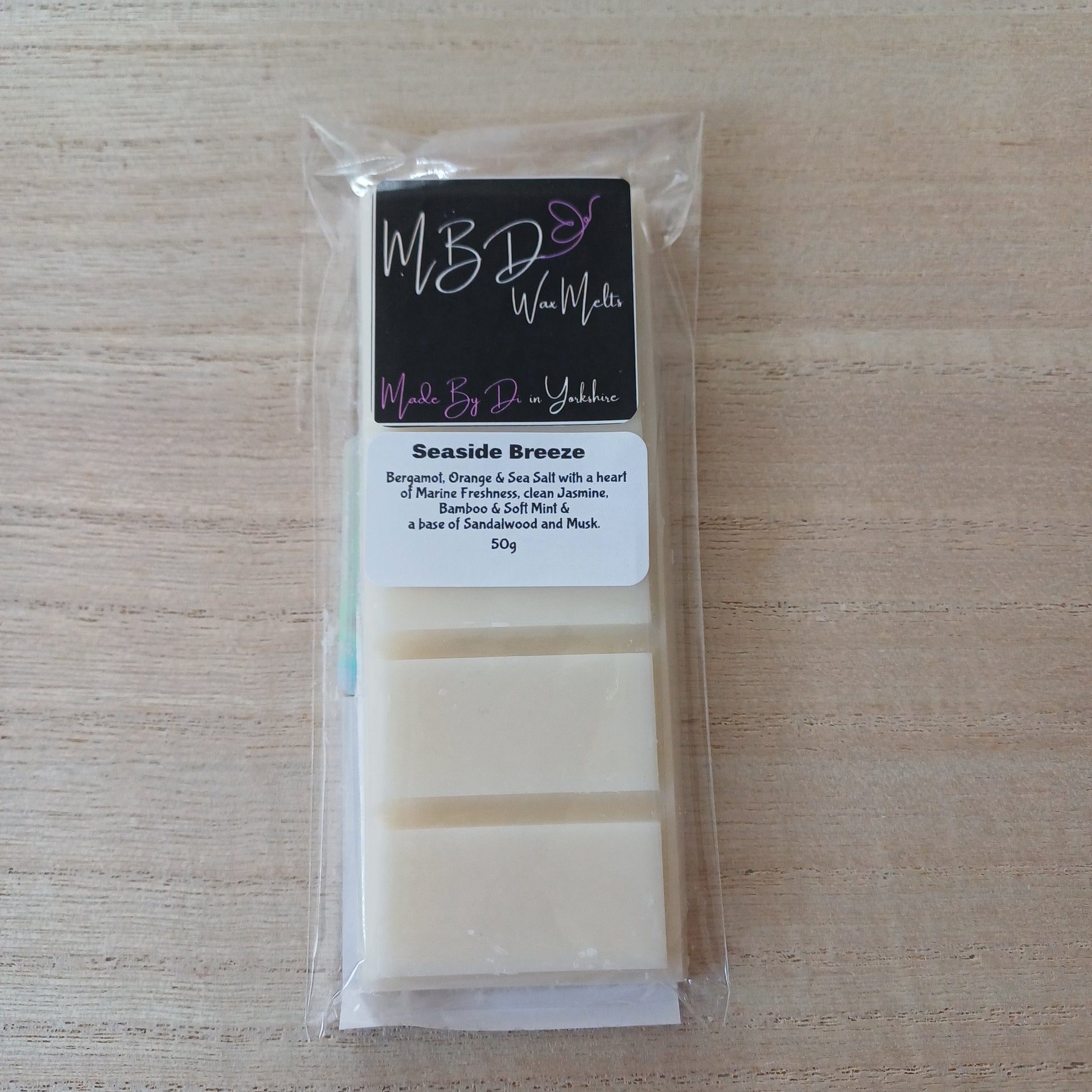 Packaged wax melt with brand label on a wooden surface