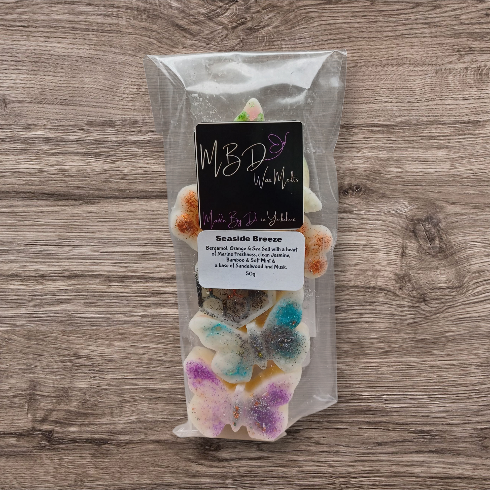 Packaged wax melts with butterfly design on a wooden surface
