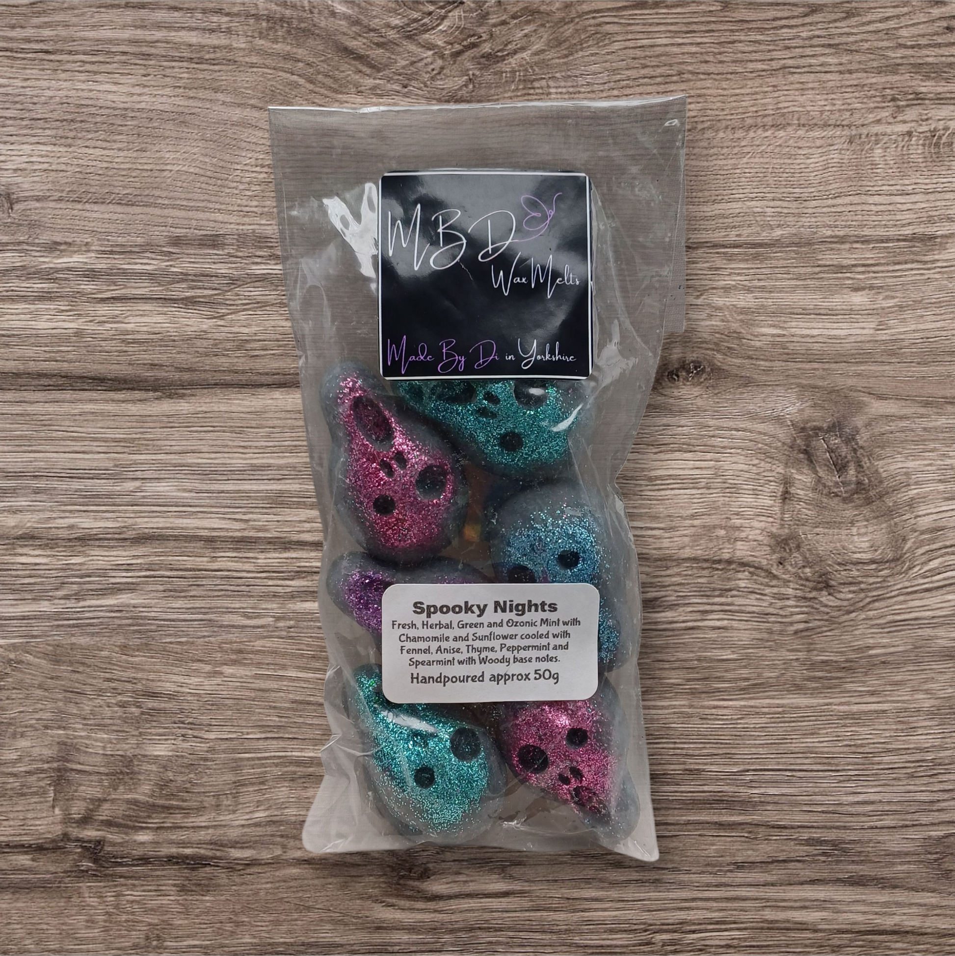 Packaged product with colorful skulls and a label on a wooden surface