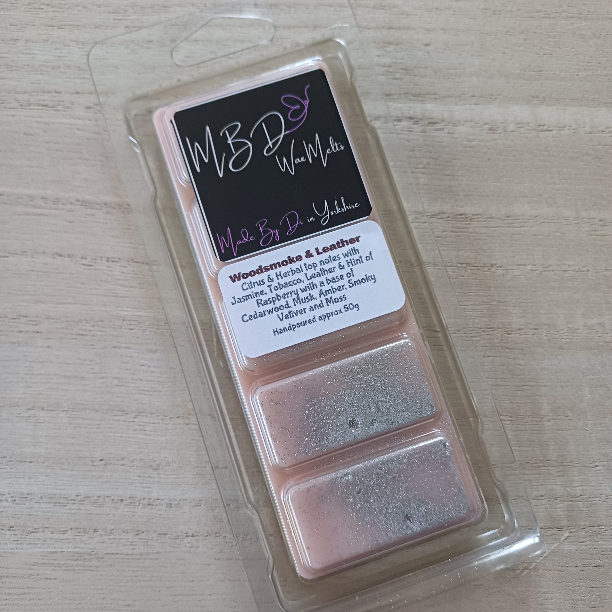 Packaged wax melt with a label on a light wooden surface