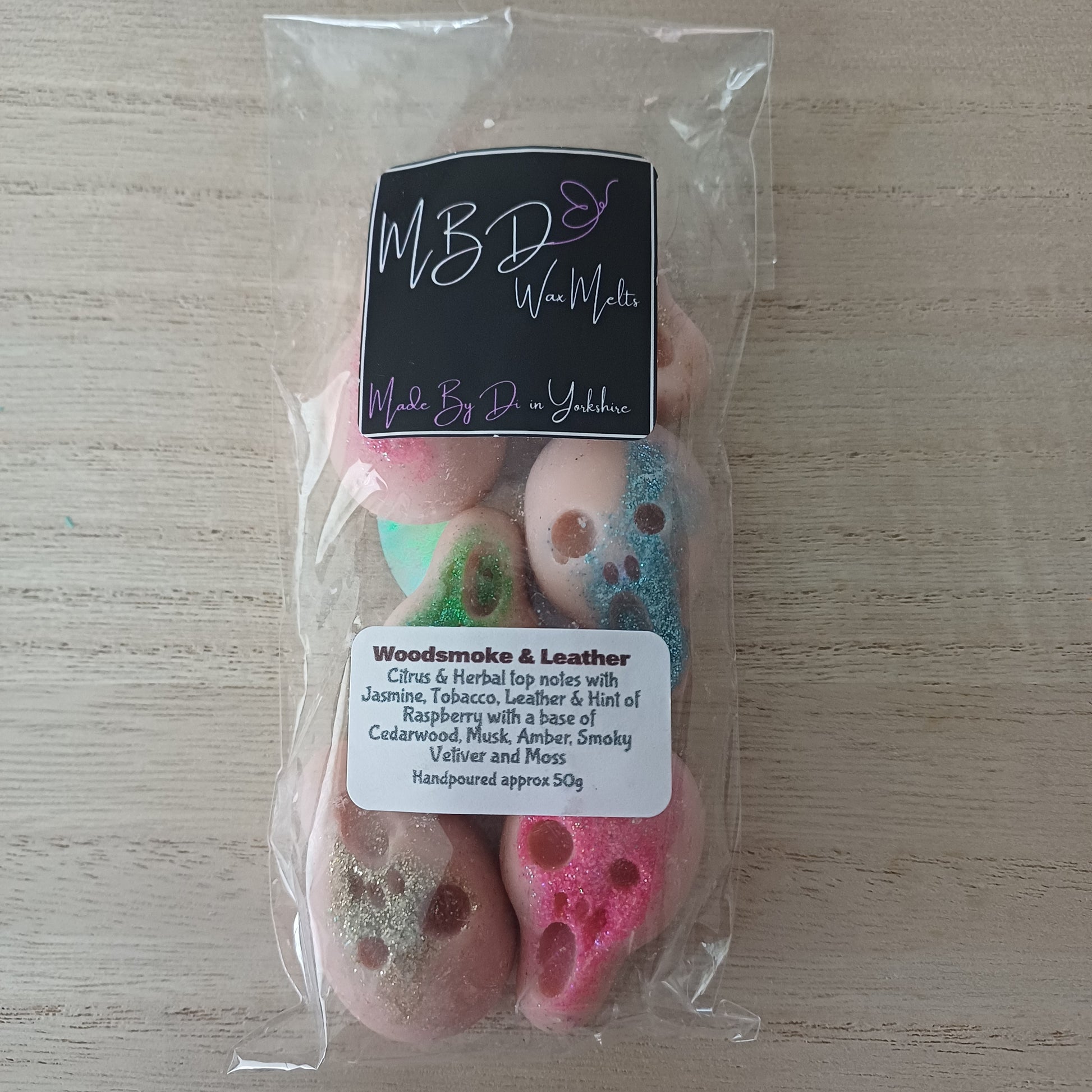 Packaged Skull Wax Melts with colourful glitter and a visible brand label on a wooden surface.
